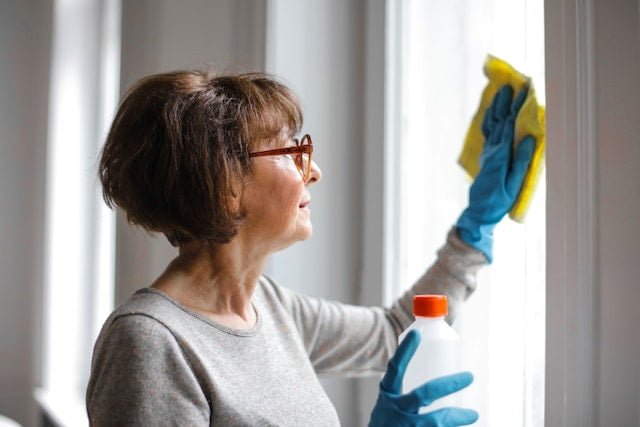 A woman wiping the surfaces using a sanitizing solution