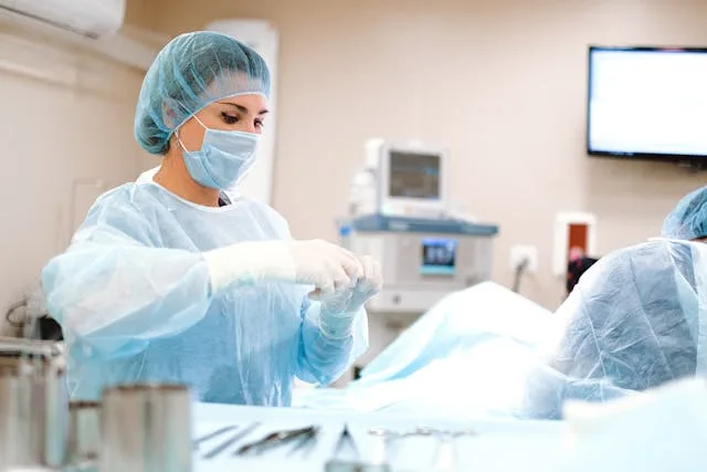 A healthcare professional wearing protective gear while performing an open surgery