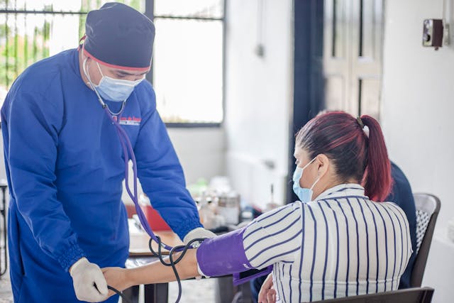 The blood pressure of a patient is checked by a healthcare provider